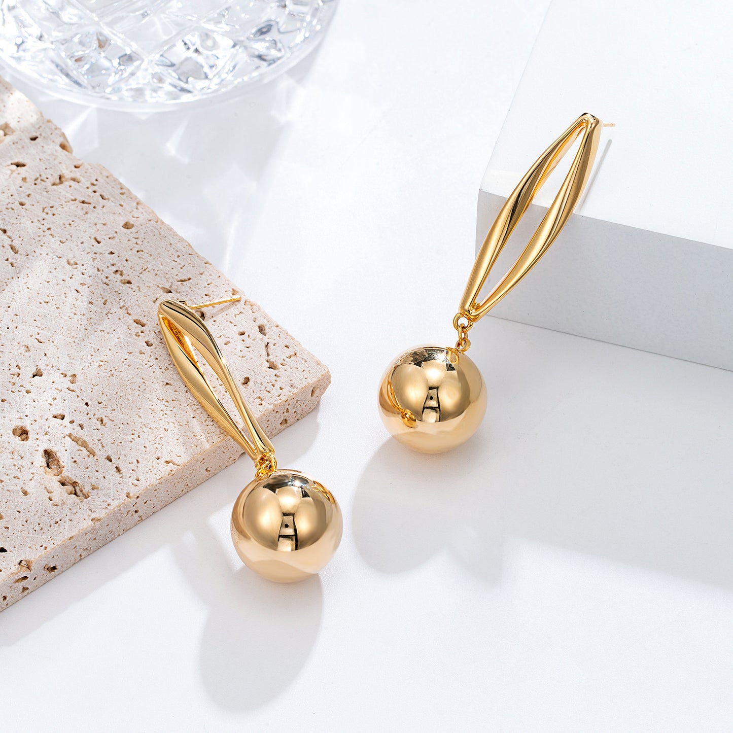 Boucles d'oreilles dorées pendantes sphère élégante